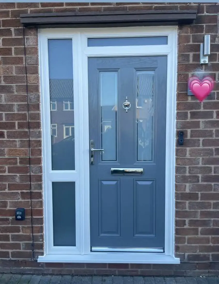 A grey composite door with a glazed side panel and top light