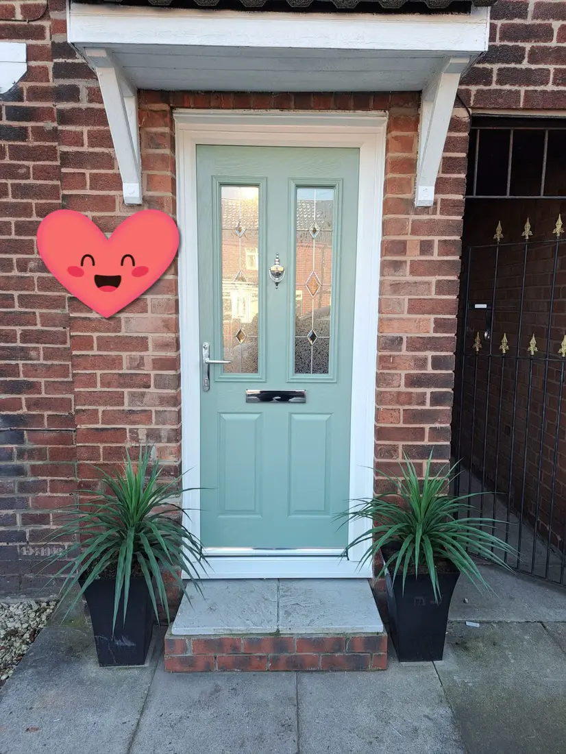 A pale green composite door with leaded glass under a porch canopy